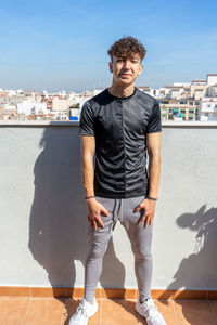 Full length of young man standing against wall