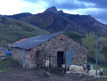 House by mountains against sky