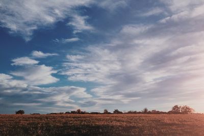 Scenic view of field against cloudy sky