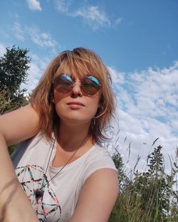 Portrait of woman with sunglasses against sky. young woman in nature.  smiling 