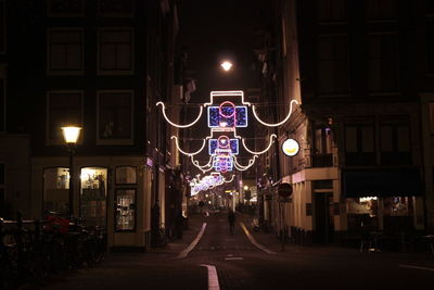 Illuminated decoration on street amidst buildings at night