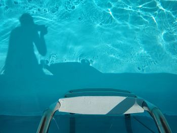 Reflection of woman swimming in pool