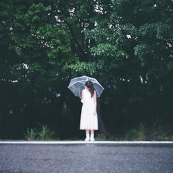 Full length of woman standing on tree trunk