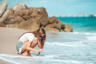 Side view of young woman standing in sea