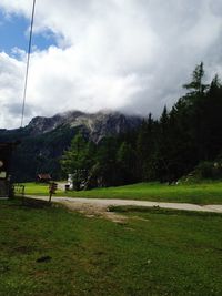 Scenic view of green landscape and mountains against sky