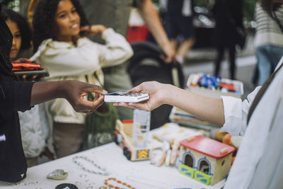 Woman doing payment through credit card while shopping at flea market