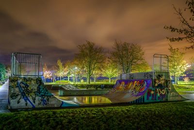 Graffiti on swimming pool at park against sky