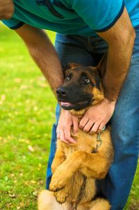 Cropped image of man holding dog