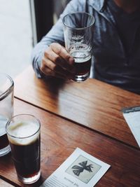 Close-up of man holding drink on table