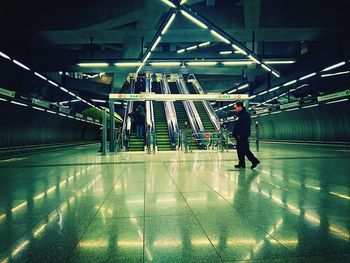 Man standing at illuminated subway station