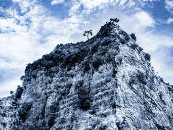 Cold dramatic mountain peak with scattered trees and cloudy sky background in ratchaburi thailand