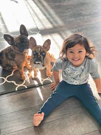 Portrait of cute girl with dog on floor