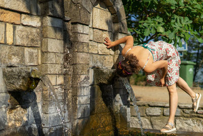 Woman drinking water from fountain