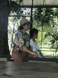 Rear view of women sitting against trees