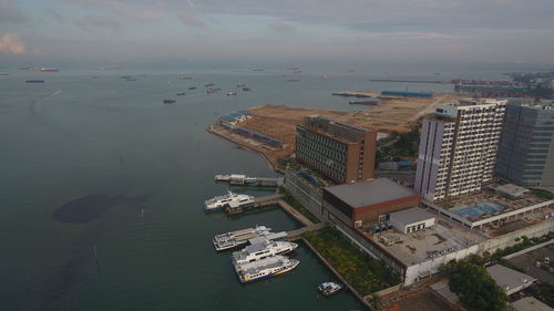 High angle view of buildings by sea against sky