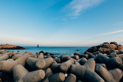 Rocks on sea shore against sky