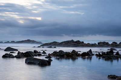 Rocks in sea against sky