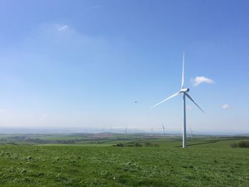 Windmill on field against sky