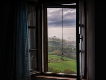 Scenic view of field seen through window