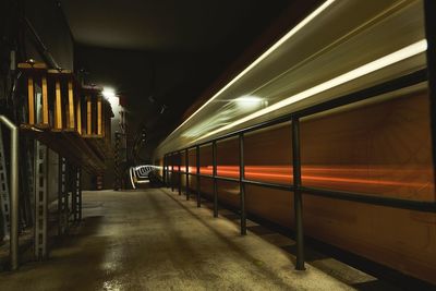 Train at railroad station platform at night