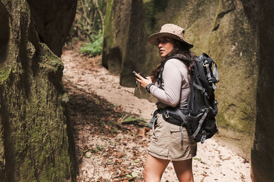 Woman with gps and backpack looking back.