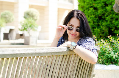 Portrait of young happy brunette asian woman relaxing in city, park. summer vacation. travel