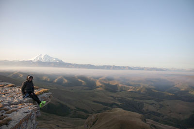 Man looking at mountain range against sky