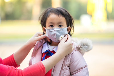 Schoolgirl wearing n95 mask to prevent deadly virus and air pollution.