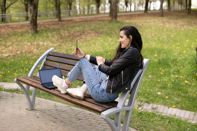 Young woman sitting on bench at park