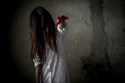 Side view of evil woman sitting in bathroom while holding knife