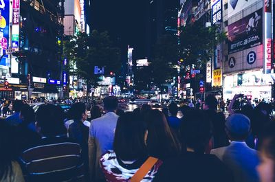 People walking on city street at night