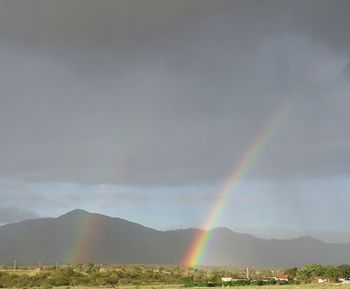 Rainbow over mountain against sky