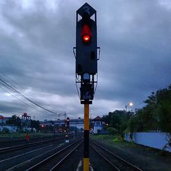 Railroad tracks against cloudy sky