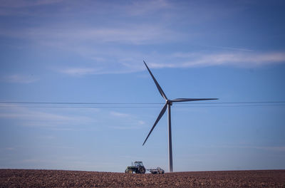 Windturbine on field against sky