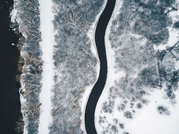 Directly above shot of road amidst snow covered field 