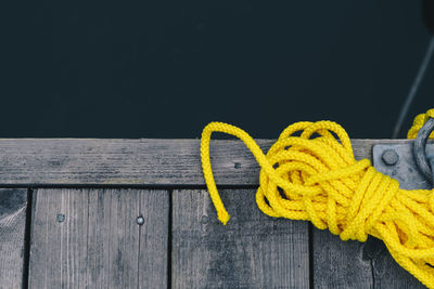 Close-up of yellow rope against railing