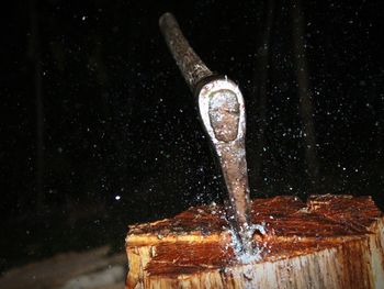 Close-up of water splashing on wood with axe