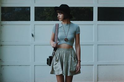 Young woman standing against wall