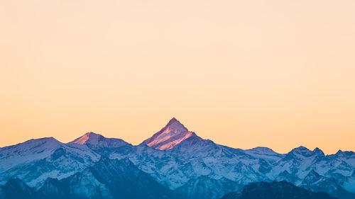 Scenic view of snowcapped mountains against clear sky during winter