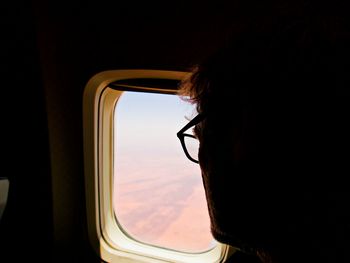 Portrait of woman looking through airplane window