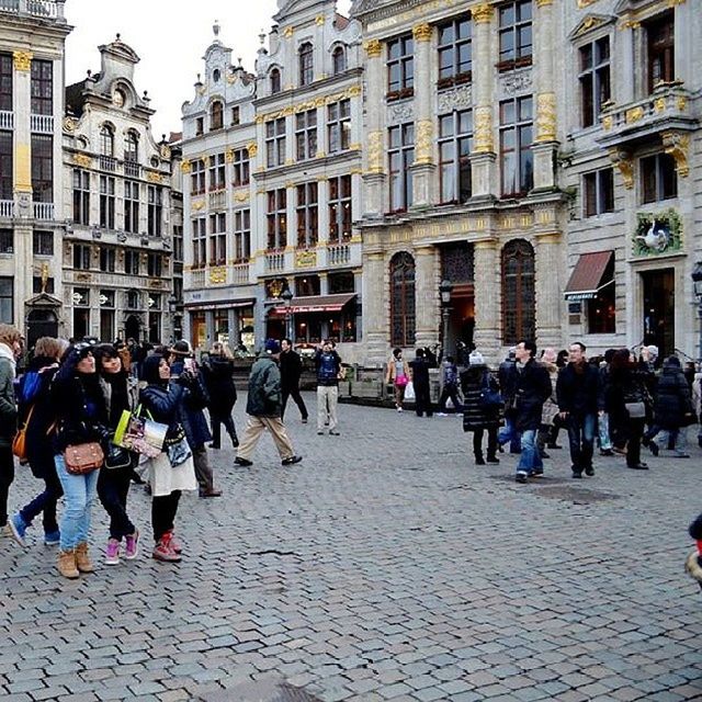 architecture, building exterior, large group of people, built structure, person, men, cobblestone, street, city, walking, lifestyles, city life, leisure activity, mixed age range, arch, town square, tourist, old town, crowd