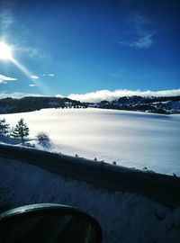 Scenic view of snow covered mountains against blue sky