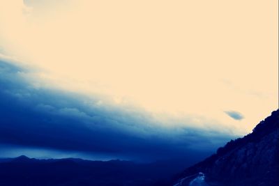 Scenic view of mountains against cloudy sky
