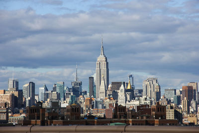 View of cityscape against cloudy sky