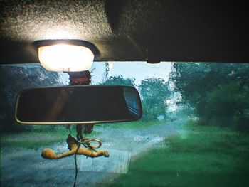 Close-up of illuminated electric lamp by sea