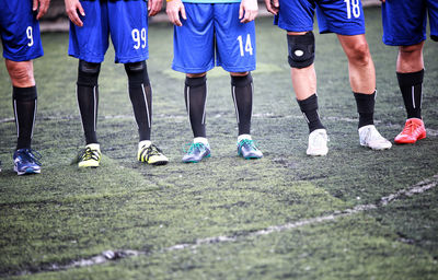 Low section of soccer players standing on playing field