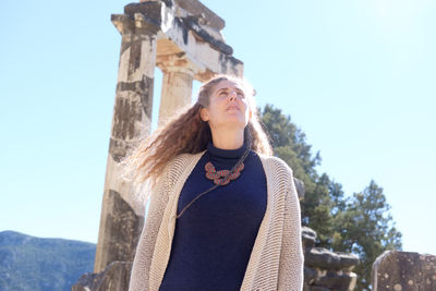 Low angle view of woman standing against sky