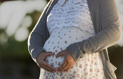 Midsection of woman standing against wall