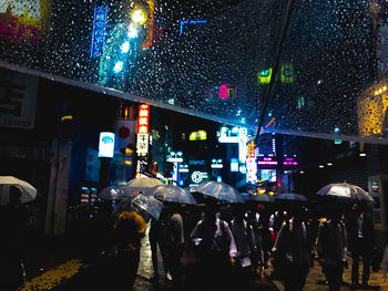 People on wet street during rainy season at night