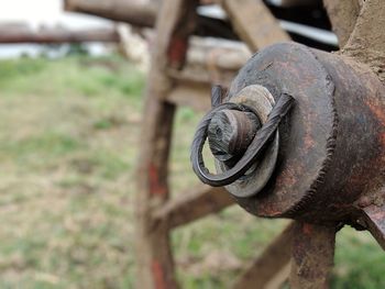 Close-up of rusty machine part on field